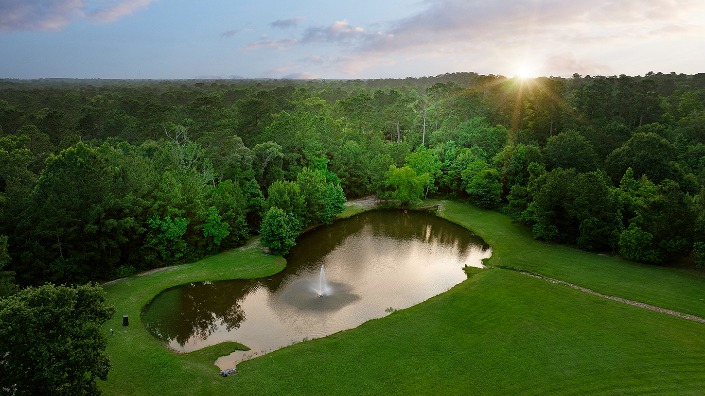 Aerial view of the private pond and grounds at sunset