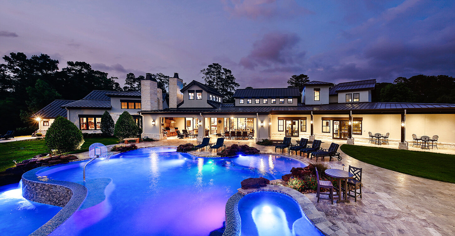 Resort-style pool and estate at dusk on 7.25 acres in Magnolia, Texas
